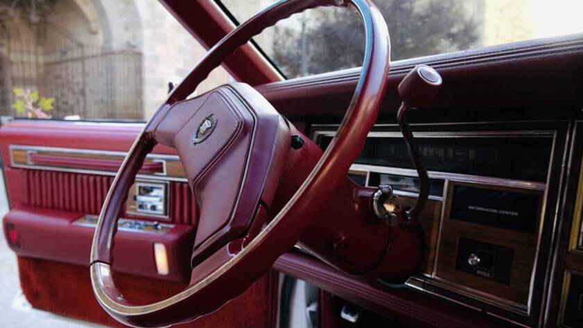Volante de coche clásico con interior rojo, detalle en primer plano.
