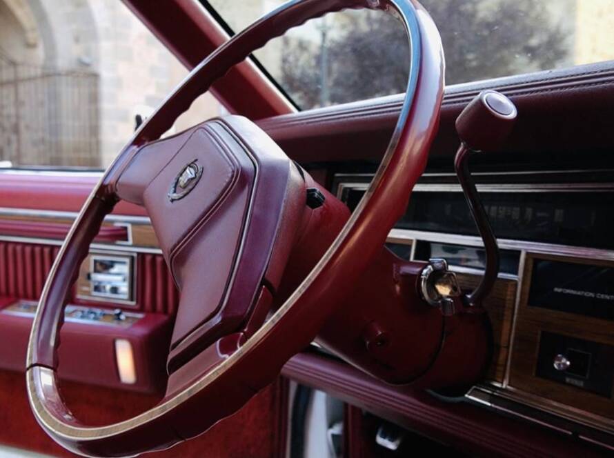Volante de coche clásico con interior rojo, detalle en primer plano.