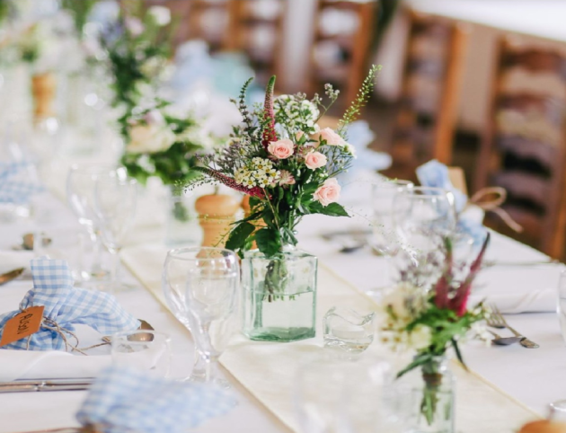 Mesa de bautizo en tonos azules con lazos de cuadros y centro floral