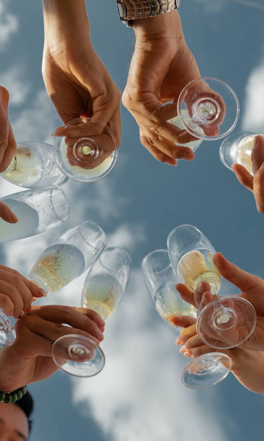 Brindis visto desde abajo con copas de cava al cielo.